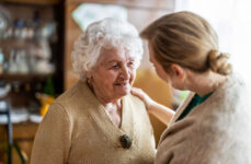 A nurse helping an elderly woman who is experiencing disorientation and confusion.